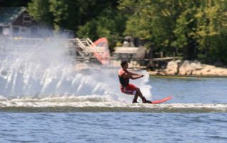 guest water skiing on the lake in front of the boat dock
